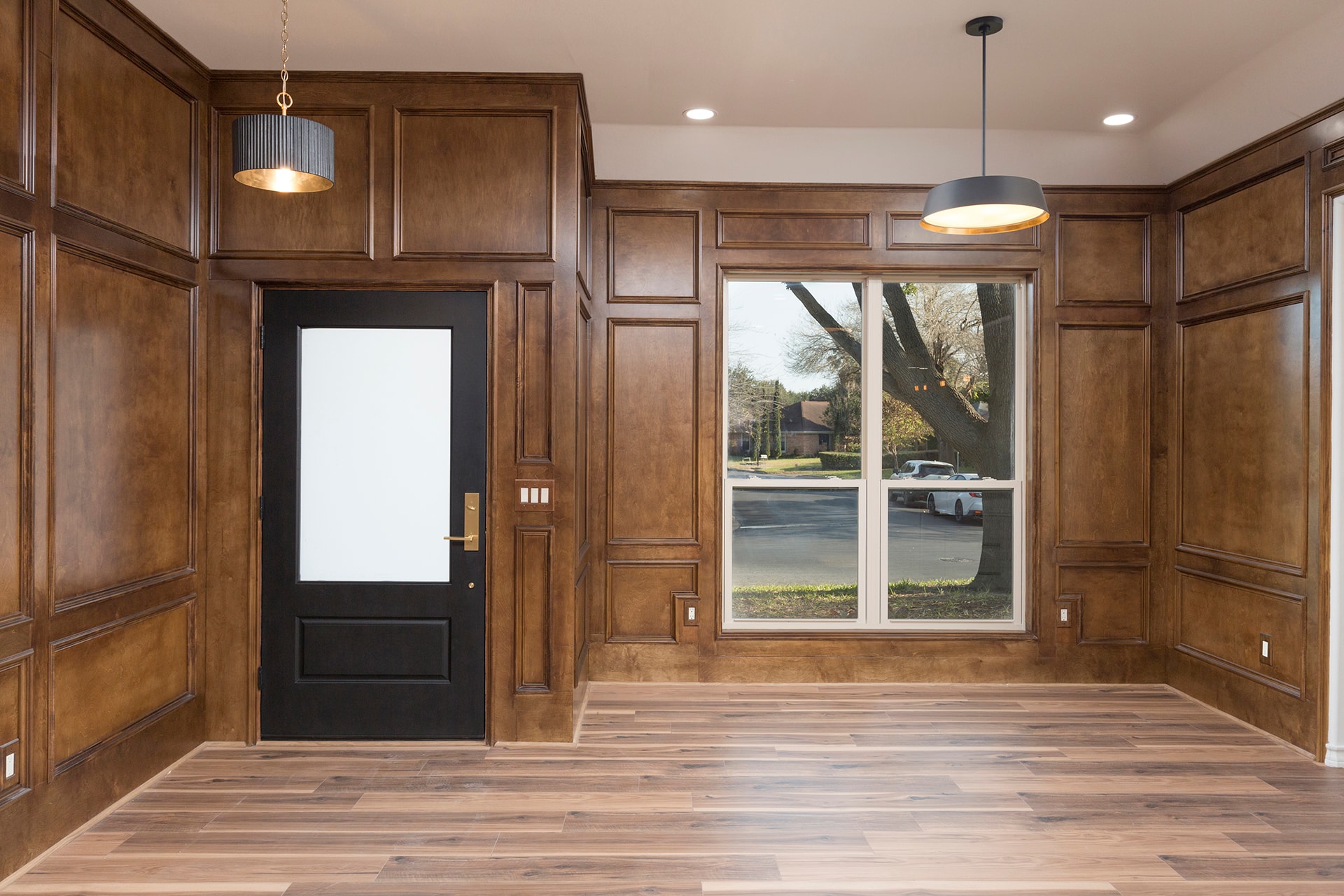 Luxury foyer wood paneling black door