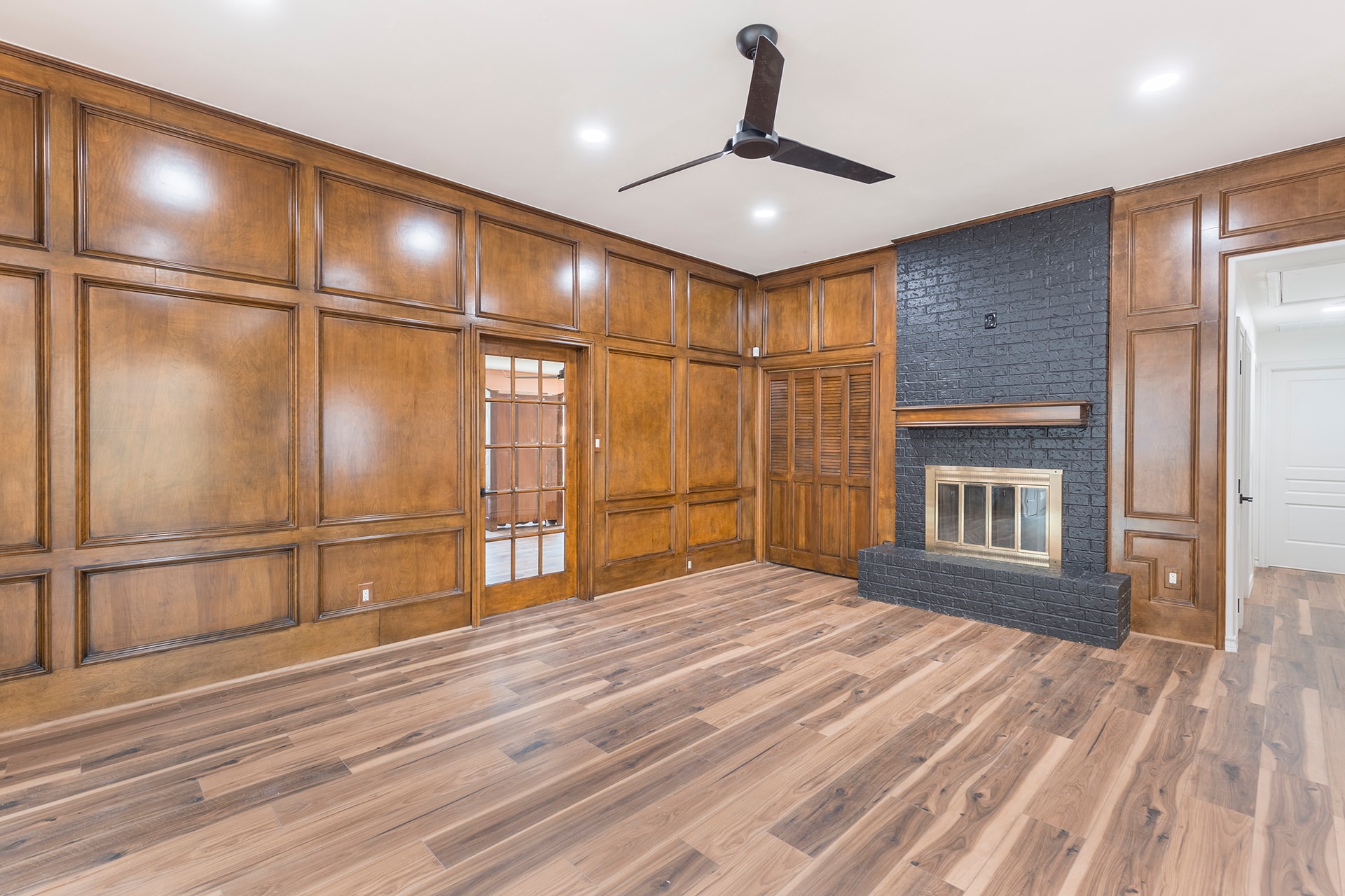 Spacious living room wood paneling fireplace
