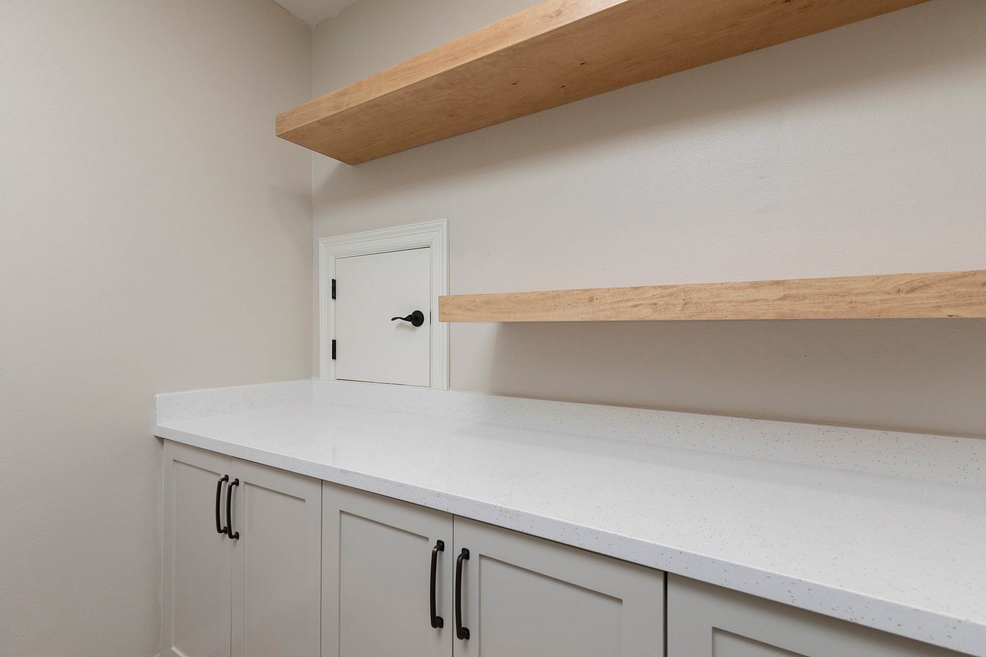 Modern kitchen with white cabinetry and wooden shelving