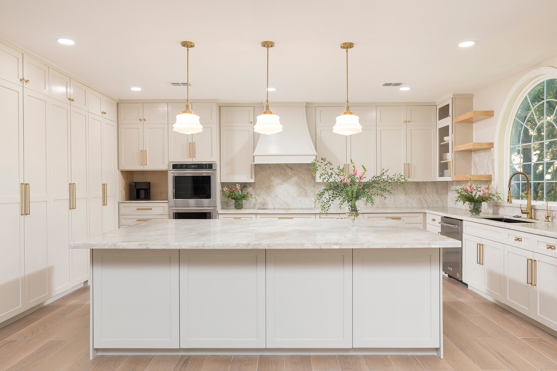 Modern white kitchen with marble island and brass hardware