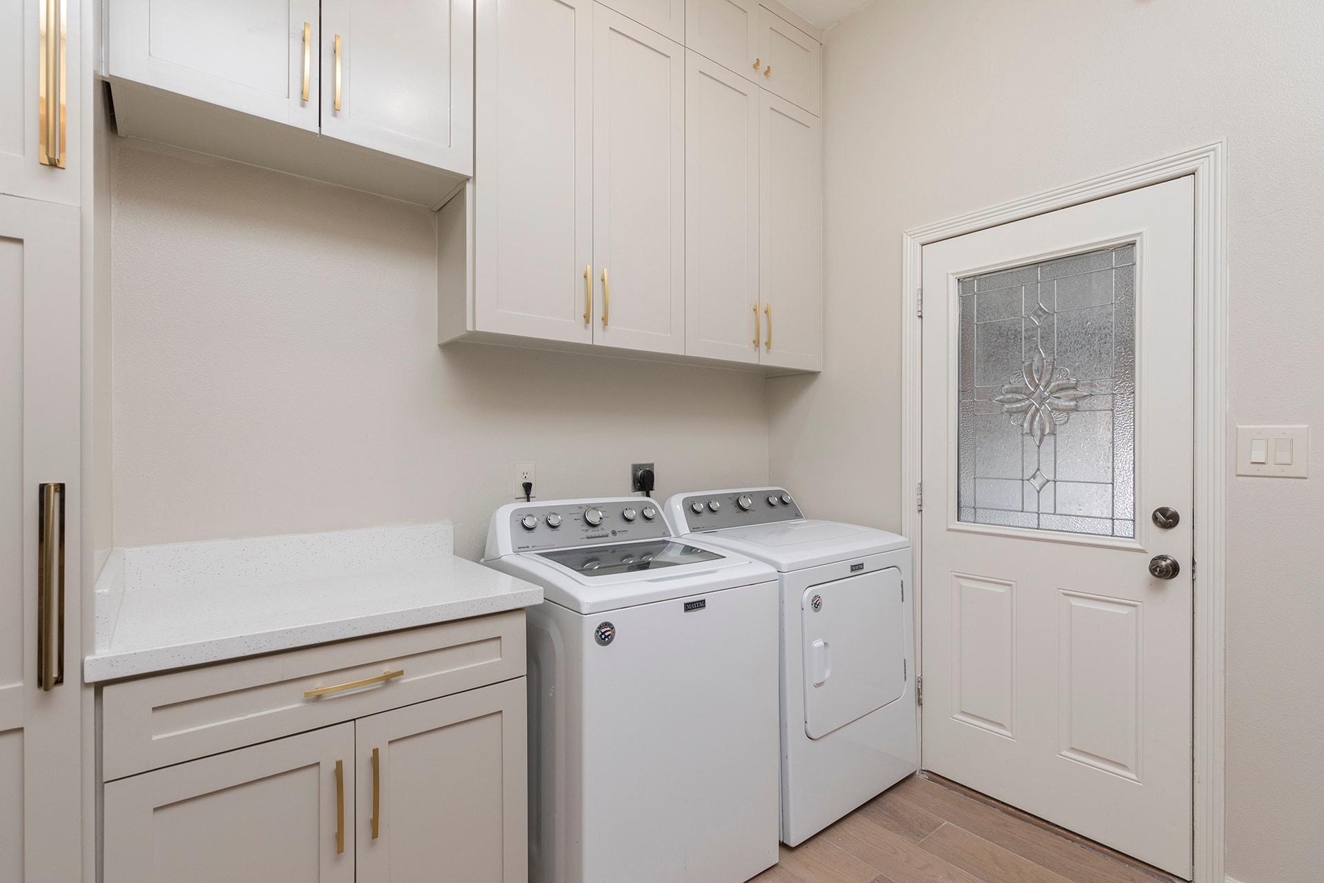 Modern laundry room with washer dryer and gold hardware