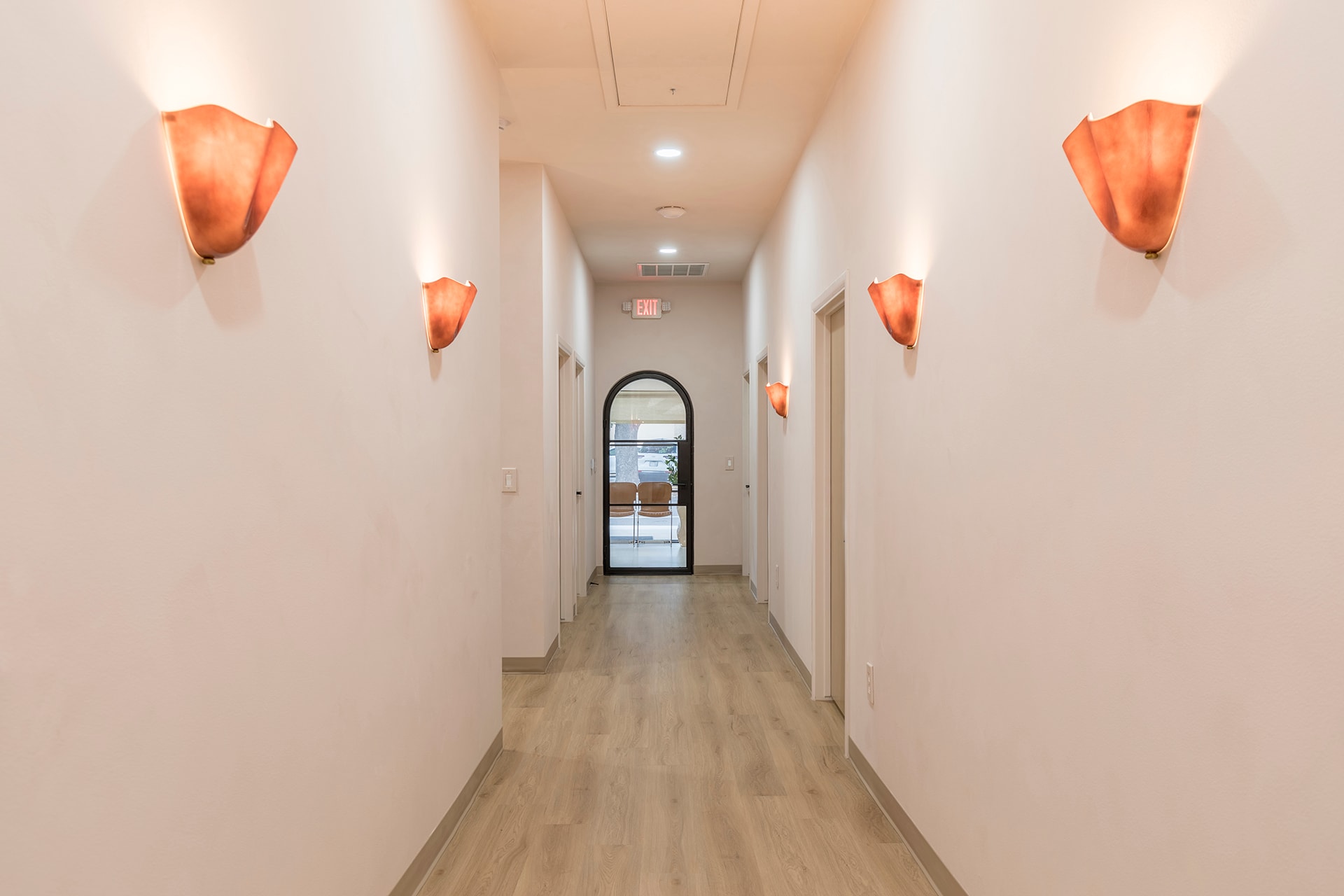 Modern hallway with orange wall sconces
