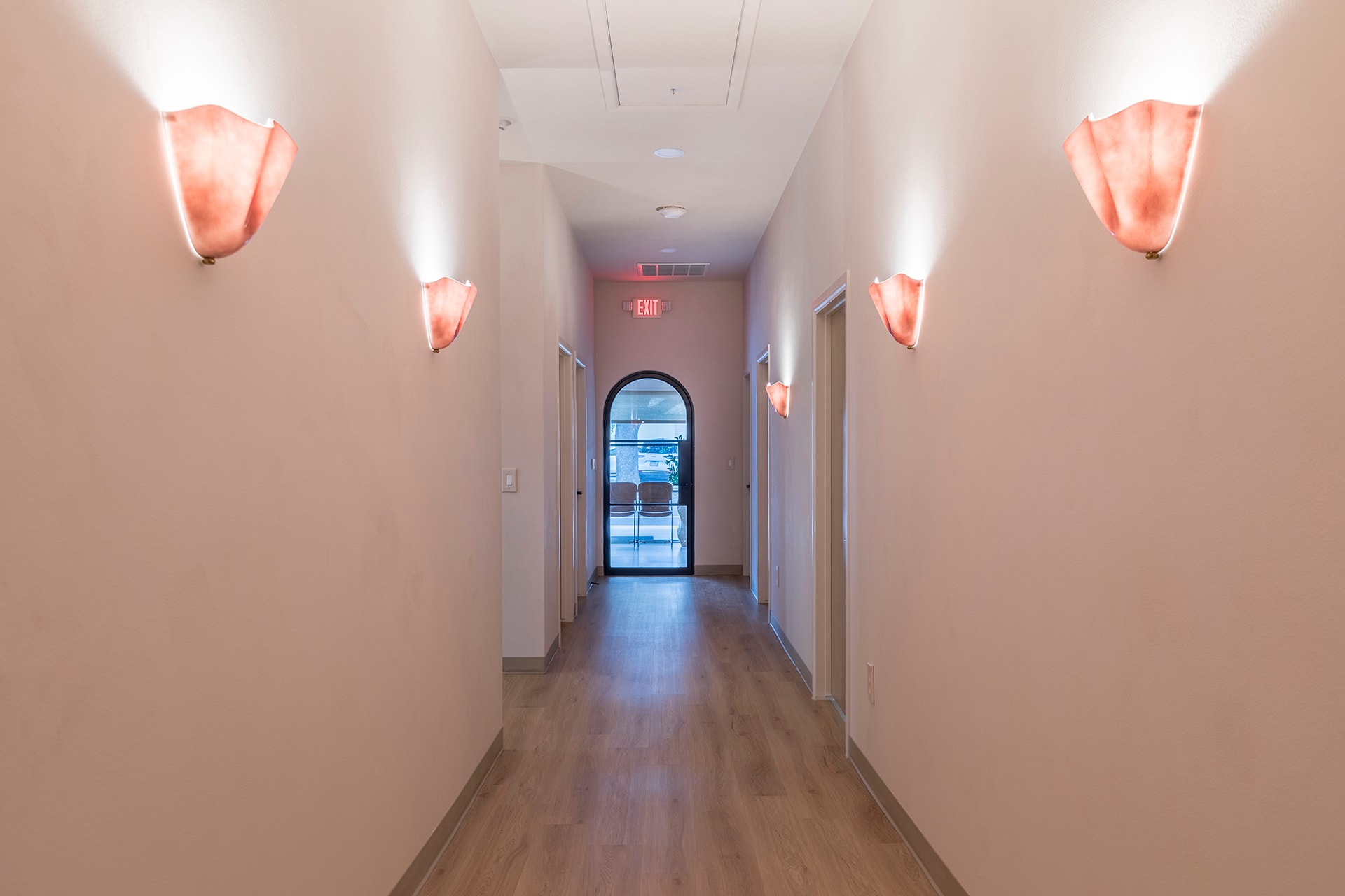 Modern hallway with coral neon sconces