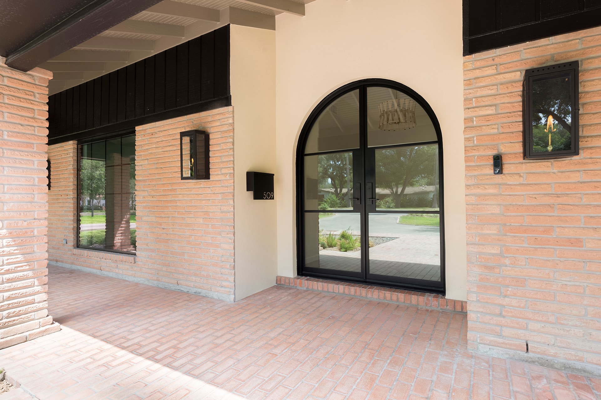Modern brick home with arched entry door