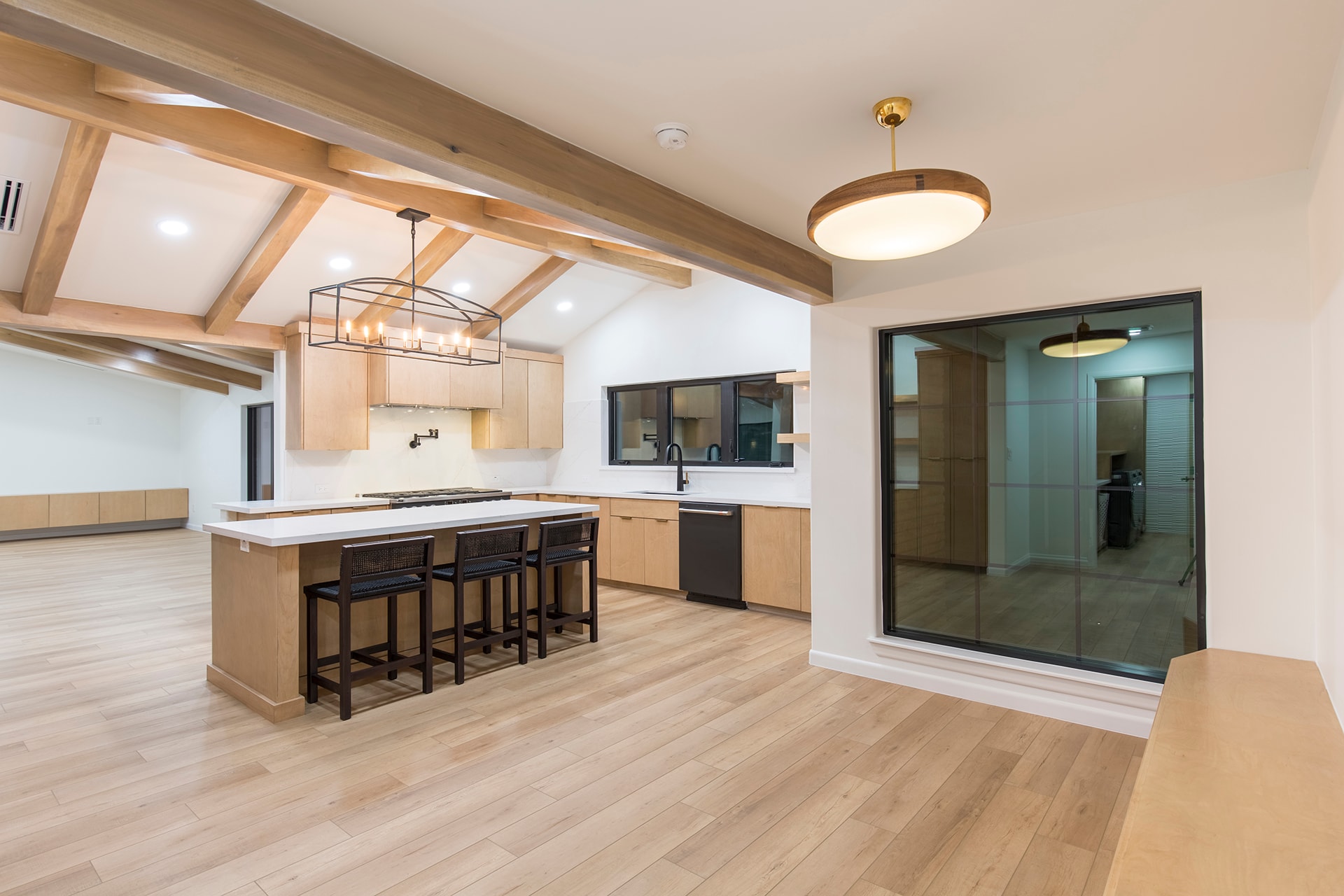Modern kitchen with island seating and wood beams